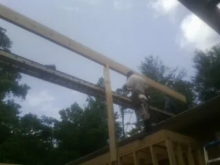 Carpenter setting a ridge beam over a new addition frame — Ice Dam Removal by Roofing Brothers in Fort Laramie