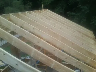 New roof rafters set over an addition before sheathing in Fort Laramie