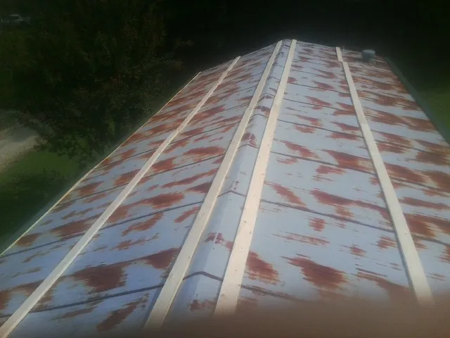 Rusted metal roof panels with new wood purlins before replacement — Storm Damage Roof Repair in Fort Laramie by Roofing Brothers