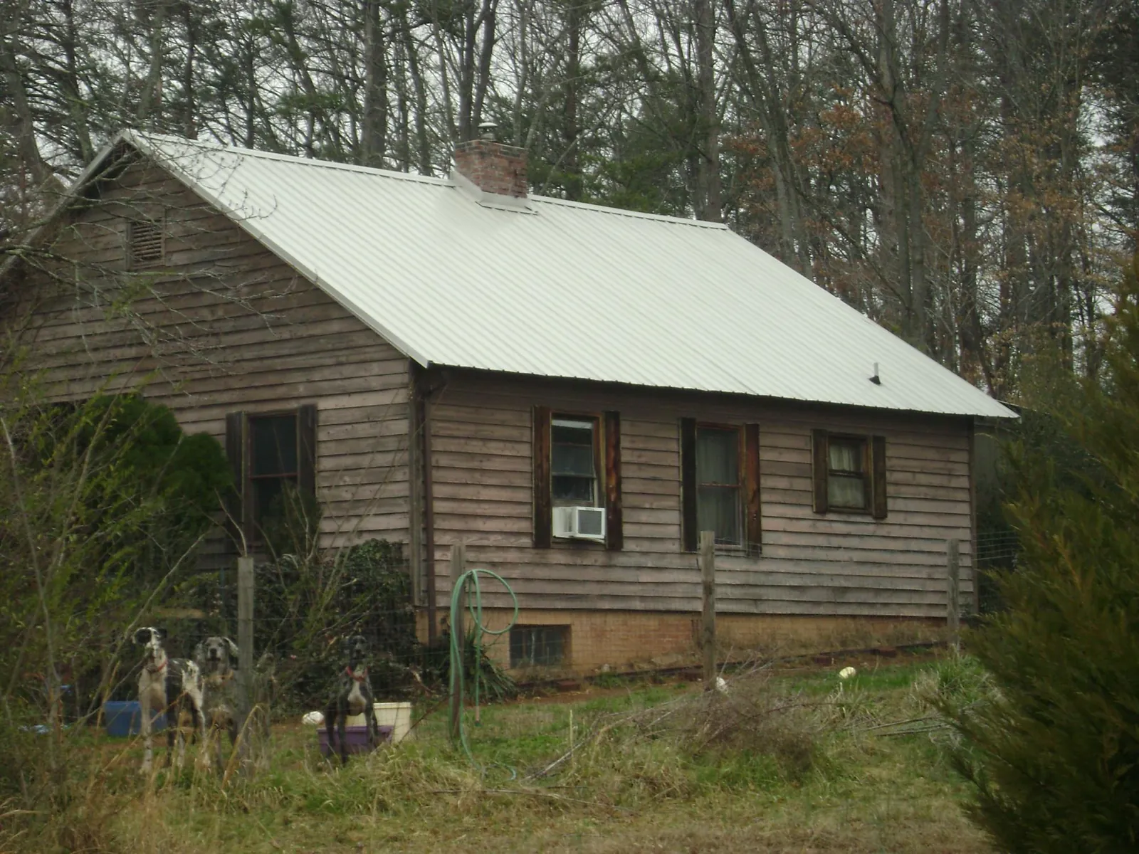 White metal roof on an old wood sided farmhouse, from a Metal Roof Installation job in Fort Laramie